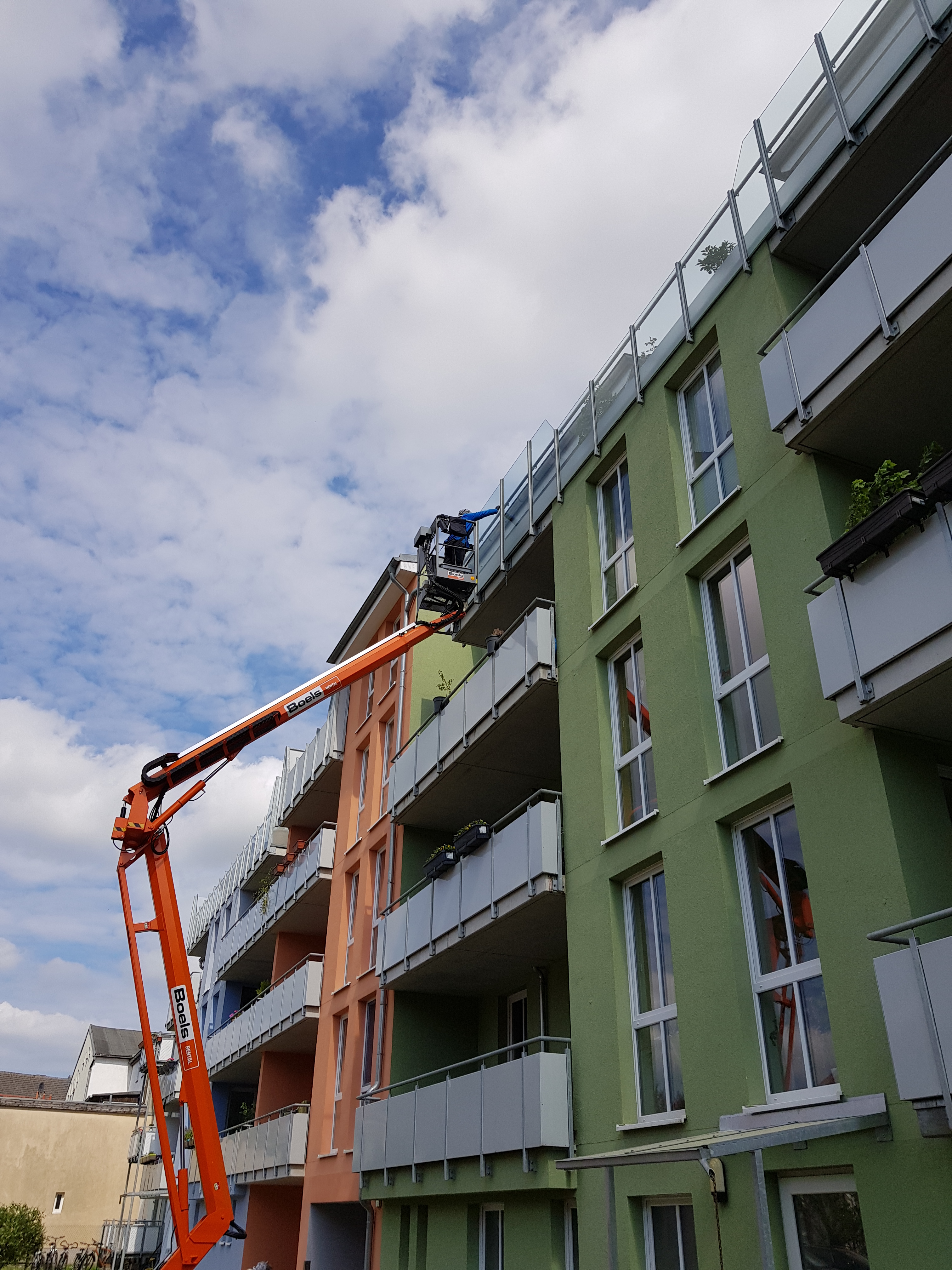 Reinigung von Scheiben eines Balkons in der vierten Etage